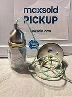 Pendant light showing jar shade, brushed nickel cap, cord and canopy