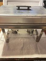 Front view of assembled chafing dish showing lid, frame and overall condition