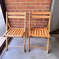 Front view of both wooden folding chairs standing side by side