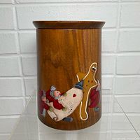 Front of teak canister showing painted gingerbread scene