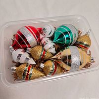 All nine ornaments in plastic tub showing colours, shapes and finishes