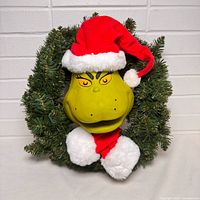 Front view of Grinch wreath showing face, hat and evergreen branches