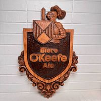 Front view showing shield shape, knight figure, raised lettering and overall condition