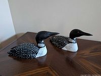Pair of wooden loon decoys on tabletop