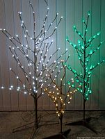 Three lit Noma LED twig trees (white 42", green 36", yellow 24")
