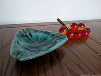 Ashtray and grape cluster on wooden surface