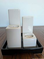 Rectangular ivory block candles on black tray