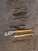 Five tools: four pliers and one file displayed vertically