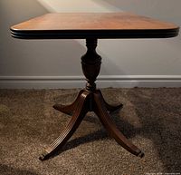 Full view of table showing pedestal base and leg with brass claw foot