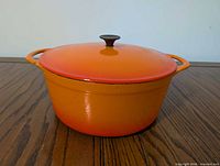 Front view of orange Cousances Dutch oven with lid