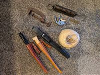Group shot showing knives in sheaths, spring scale, spreader tool, twine, C-clamp