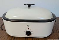 Front view of cream GE roaster oven with lid and control dial