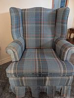 Front view of plaid wingback chair showing full design