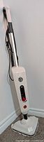 Full view of steam mop leaning against wall