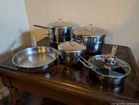 Group of Lagostina pots, frying pan and sauté pan displayed on table