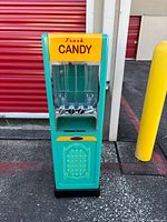 Front view showing yellow "Fresh Candy" sign, four clear bins and knobs