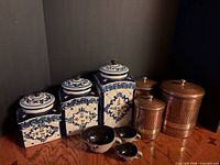 Group view of ceramic canisters, copper canisters and measuring cups