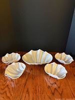 Group shot of five white shell-shaped melamine bowls on table