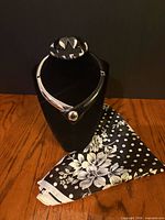 Choker displayed on bust with matching earrings positioned on top and scarf draped below