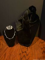 Overall view of necklace on stand and faux fur scarf on mannequin