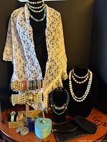 Full lot showing necklaces on busts, white lace scarf, blue display stand, bracelet rack, additional watches and accessories