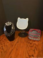 All three items together: necklace on display, cat-shaped LED mirror, polka dot cosmetic case