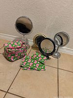 Group view of four vanity mirrors and four paisley cosmetic bags