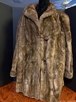 Front view of coat showing faux fur texture and toggle closures