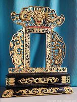 Front view showcasing full shrine frame, gilt dragons, floral scrollwork, black base