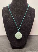 Full view of jade Bagua pendant necklace on display bust