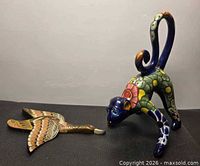 Monkey figurine beside wooden duck wall hanging showing entire lot