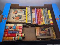 Overview of box containing assorted vintage children’s hardcovers and dust-jacketed books