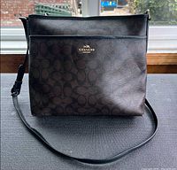 Front view of Coach signature 'C' file crossbody bag showing exterior pocket, logo, strap