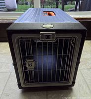 Front view of carrier showing metal wire door and latch