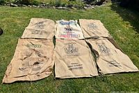 All six burlap sacks laid on lawn showing overall fronts and branding