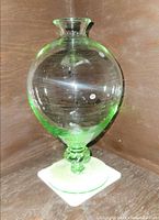 Full view of vase showing green glass, balloon form and pedestal base