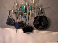 Four purses hanging on wall for size and style overview