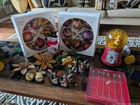 Lot overview showing ornament boxes, snow globe, napkin rings, Santa, bows, bells and fondue fork box