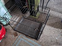 Overall view of black wire dog crate with tray
