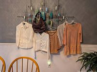 Overall view of purse and four tops hanging on wall