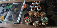 Overall lot showing one Pyrex dish, six silver/orange napkin rings, three lucite flower rings, four fruit cluster rings