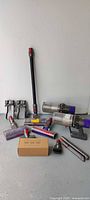 Overall lot showing all vacuum bodies, heads, wand, batteries, attachments