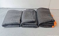 Three folded HaulMaster moving blankets side by side