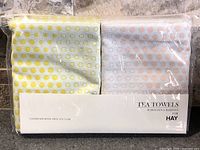 Front view of sealed package showing both tea towels and branding