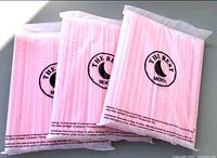 Three sealed bags of pink straws showing brand label