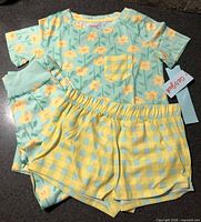 Full 3-piece set: top, pants, shorts, with hang tag visible