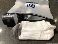 Sealed Closemate bag and one unfolded white sock pair showing grey heel/toe and ribbing