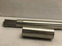 Skewers bundled inside stainless tube with cap removed showing pointed ends