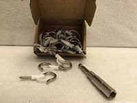 Open box showing pile of Q-hanger hooks with plastic clips and driver bit