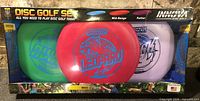 Front of sealed Innova Disc Golf Set showing three discs through window